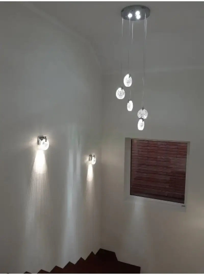 Modern gold crystal led wall lamp featuring a simple crystal led design with chrome-finished pendant light fixture and clear spherical glass globes suspended by thin cords.