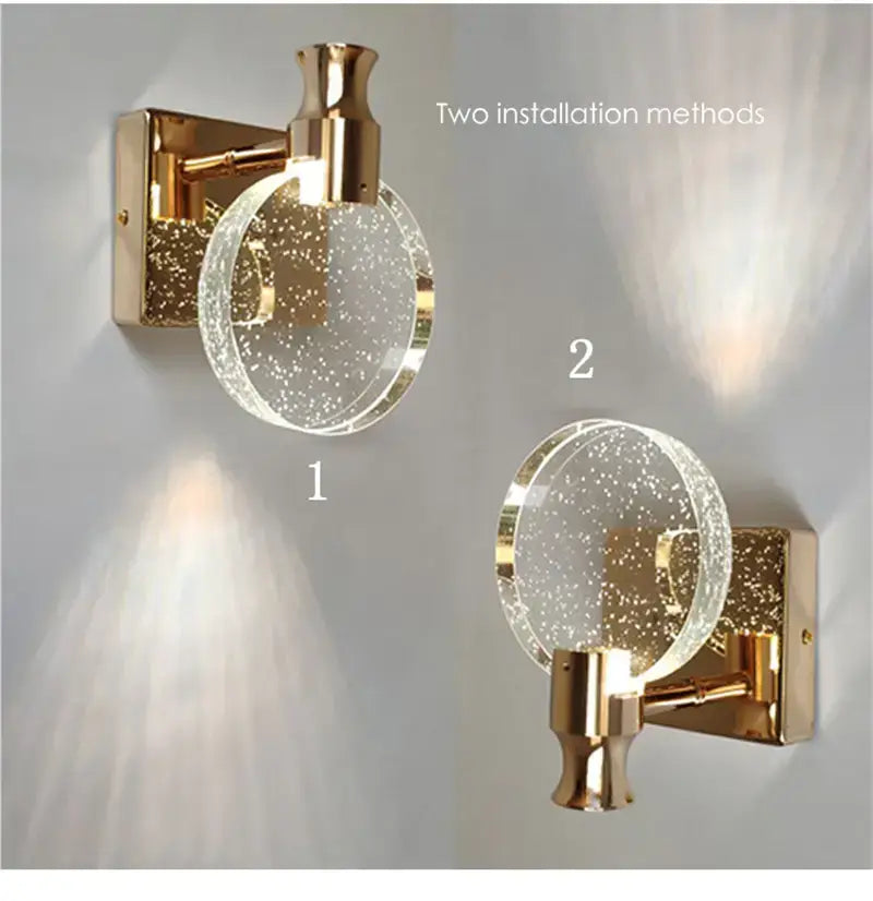 modern gold crystal led wall lamp featuring a simple crystal led wall sconce with a gold-toned base and a circular clear glass globe containing embedded sparkling particles for bathroom lighting.