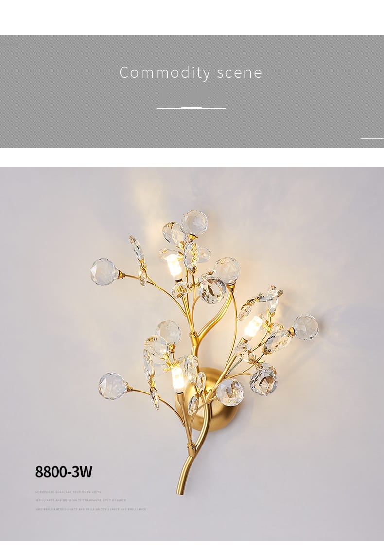 post modern luxury gold-toned wall sconce with clear crystal accents in a modern luxury branch style designed for bedroom lighting.