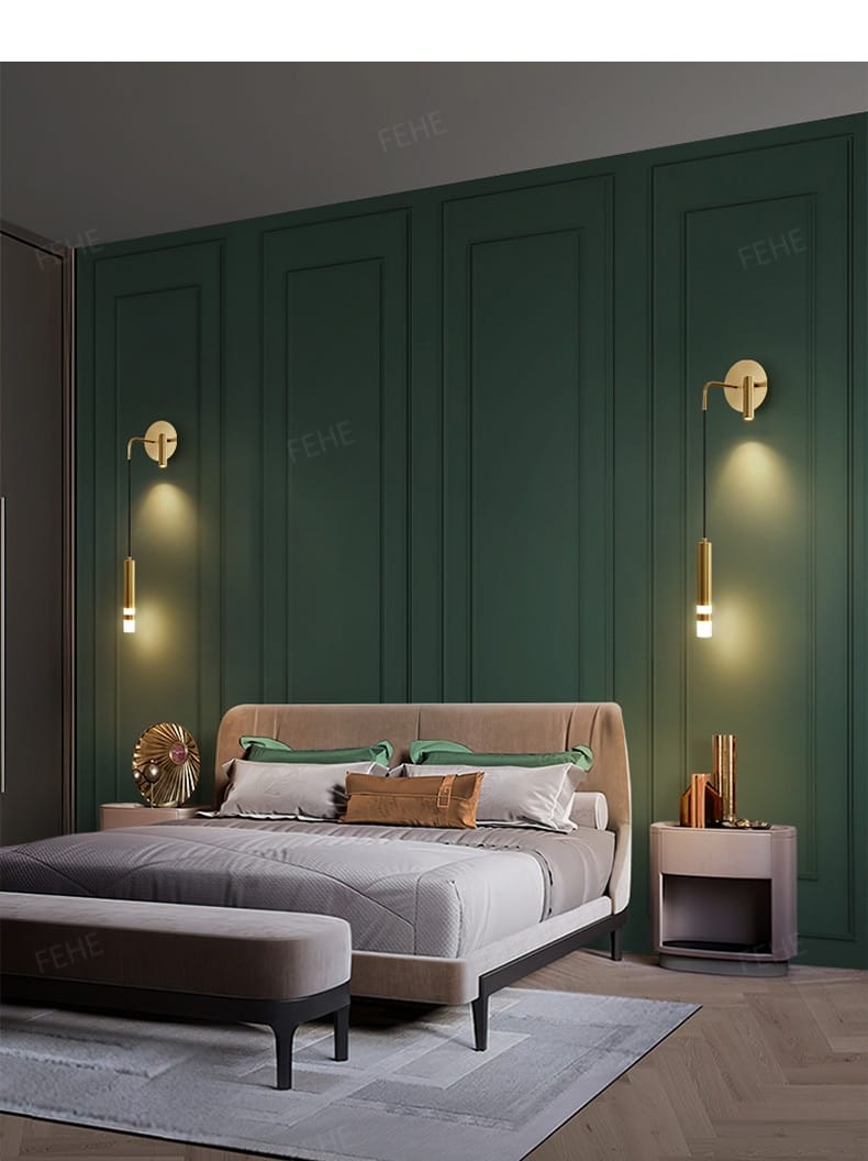 The bed with a beige upholstered headboard and gray bedding accented by green and brown pillows is complemented by a minimalist creative luxury black and gold bedside wall lamp in a luxury bedroom bedside setting.