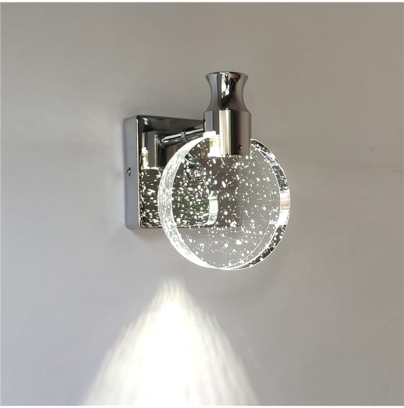 modern chrome-finished led wall lamp with a simple crystal led design featuring a circular clear glass globe embedded with white speckles for a sparkling effect.