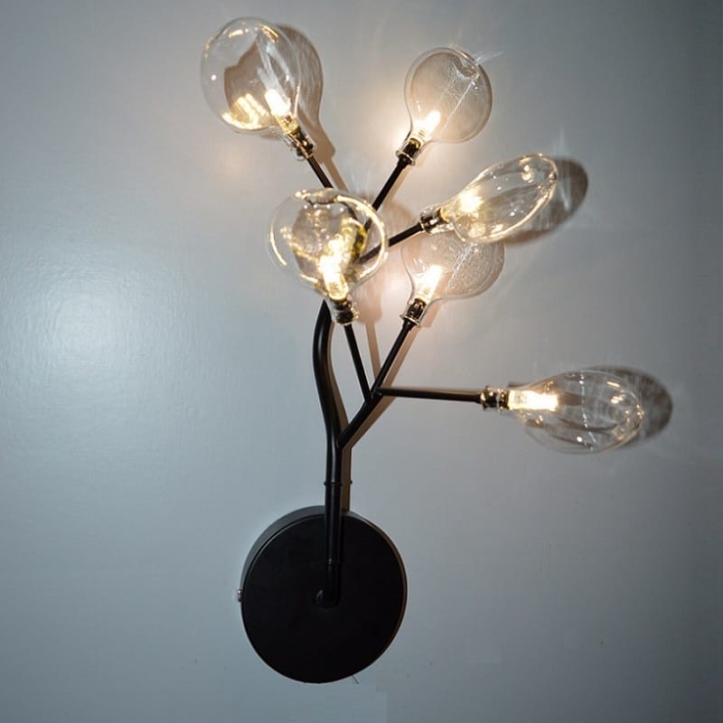 Black metal led wall light with multiple clear glass bulb arms arranged in a branching tree design for modern bedroom decor.