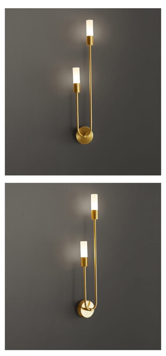 Modern gold minimalist led wall lamp featuring a gold-toned wall lamp with two slender curved arms and cylindrical frosted glass light fixtures for bedroom use.