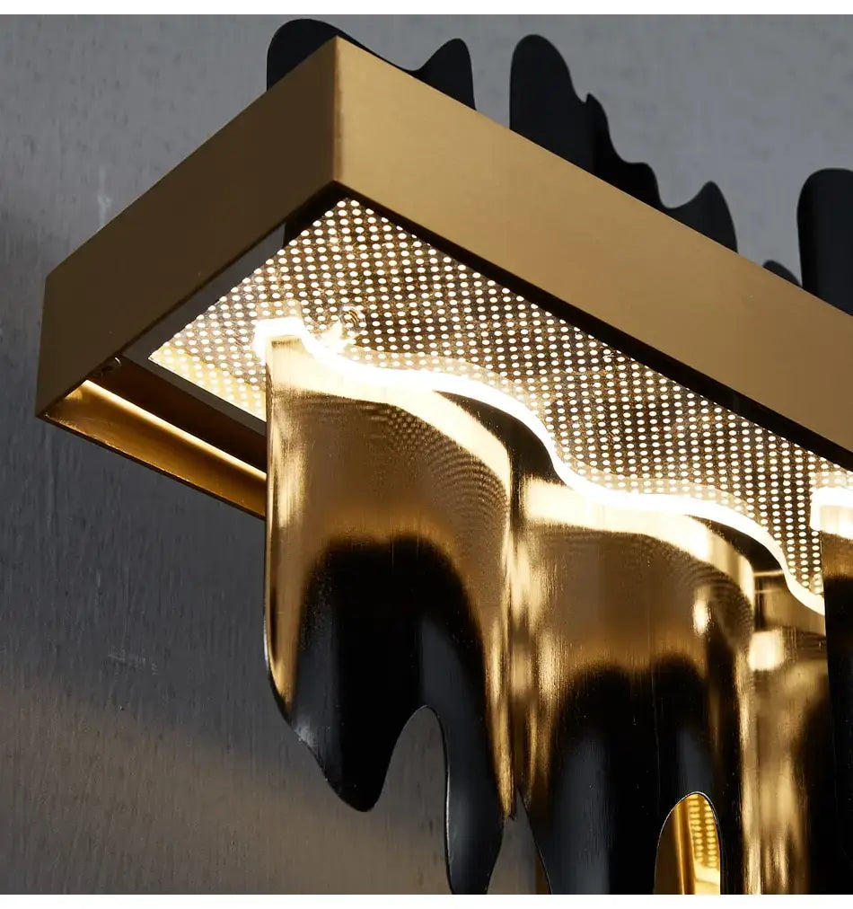 Modern gold and black wall sconce with a sleek dripping design as part of led chandelier lighting for dining room use.