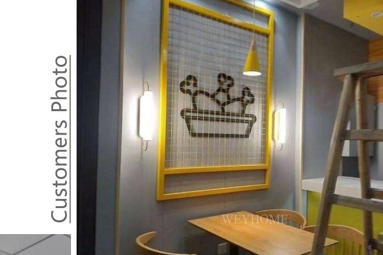 Yellow framed wall art featuring a black cactus silhouette on a wire mesh background illuminated by a modern minimalist gold led wall lamp cylindrical sconce for bedroom use.