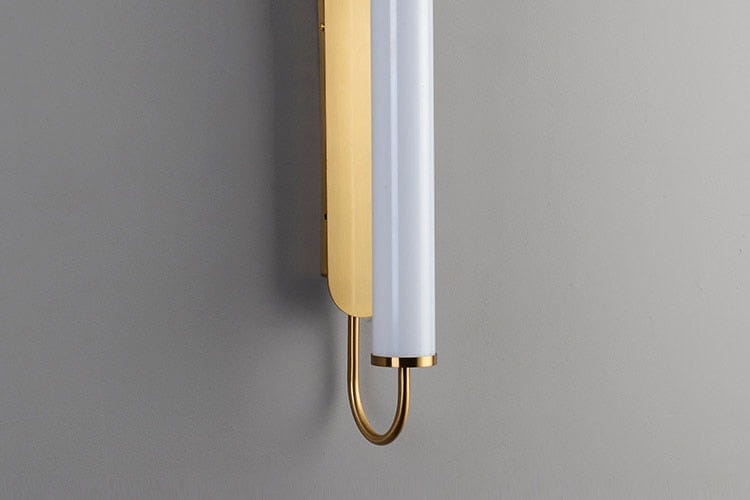 A sleek modern minimalist gold led wall lamp with a matte white cylindrical glass shade and polished gold metal accents designed as a bedroom cylindrical sconce.