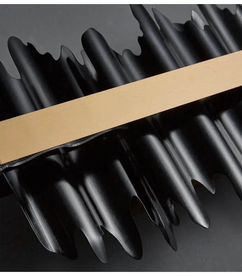 Black metallic sculpture with a gold accent bar in modern gold and black iceberg led chandelier lighting for dining room use.
