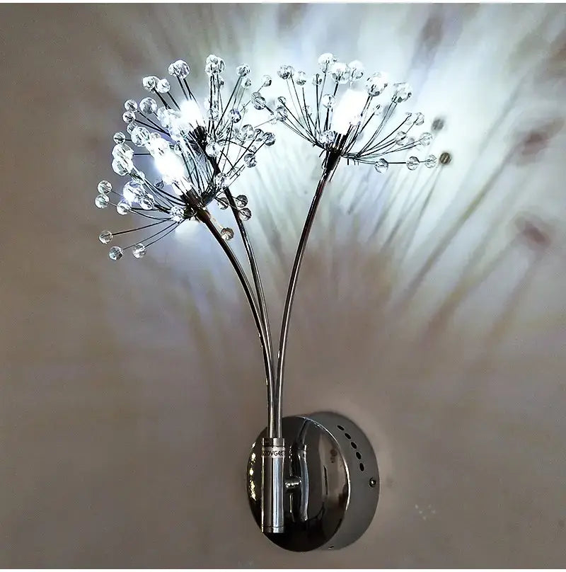 Chrome finished nordic creative crystal wall lamps featuring a creative crystal flower design with two dandelion like stems adorned with clear crystal beads, ideal for bedroom lighting.