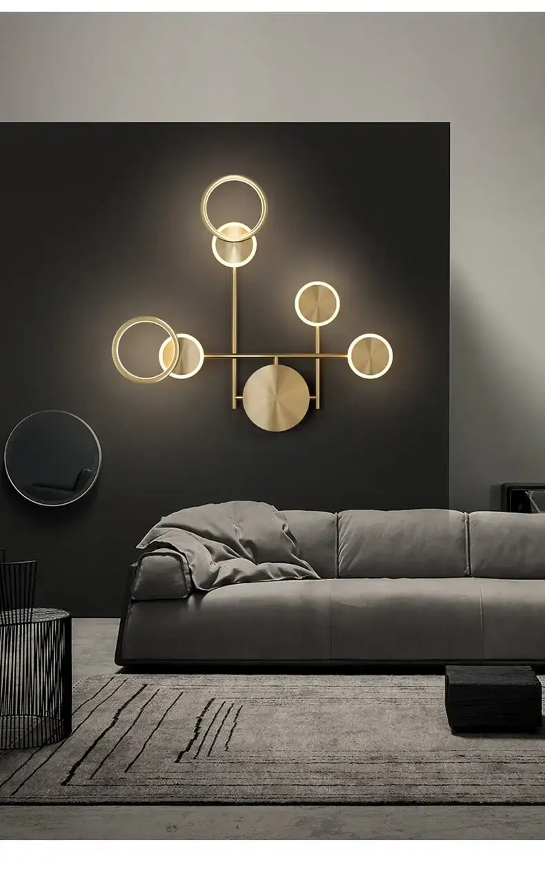 Modern golden geometric led wall lamp featuring a gold-toned circular design with illuminated rings and a central disc, ideal as a wall lamp for the living room.