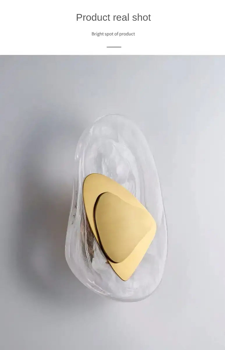 modern creative minimalist glass wall lamp featuring a gold-toned triangular-shaped object inside a clear translucent glass container for bedroom bedside lighting