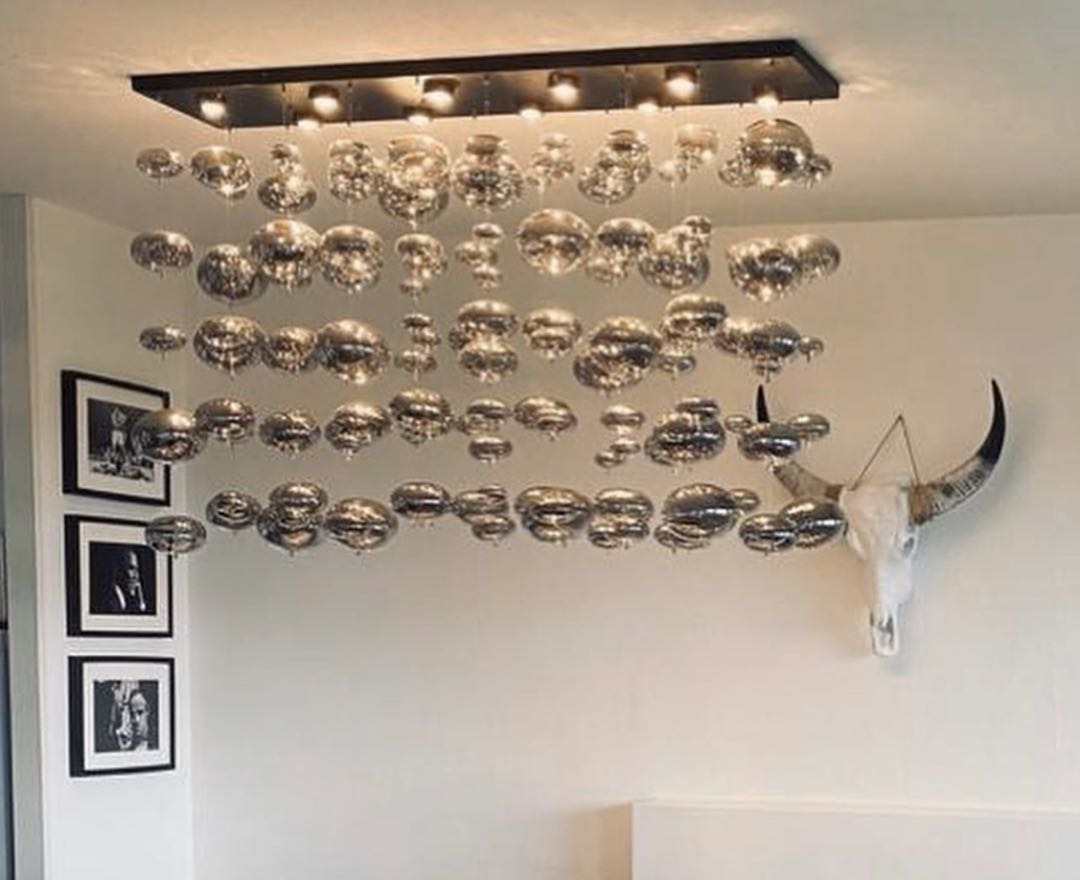 a modern oval bubble ball silver chandelier with multiple spherical glass shades arranged in a cascading pattern for dining room lighting.