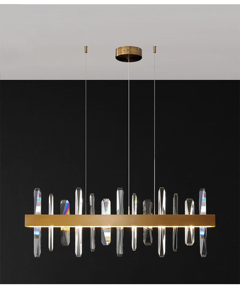A modern rectangle gold crystal chandelier featuring a sleek horizontal bar and hanging crystal prisms that refract light for dining room illumination.