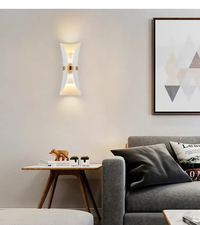 Modern white wall lamp with a gold accent band featuring a curved design for bedroom use.