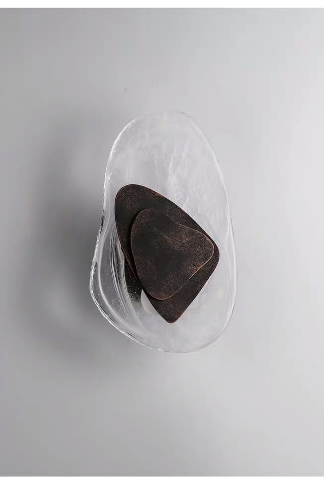 dark brown textured guitar picks displayed in a clear glass bowl complement modern creative minimalist glass wall lighting for bedroom bedside use