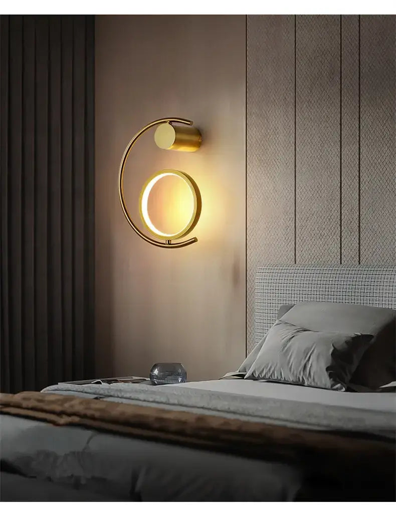 Modern gold luxury creative led bedside wall lamp featuring a circular wall sconce with a sleek illuminated ring and a cylindrical accent for bedroom use.