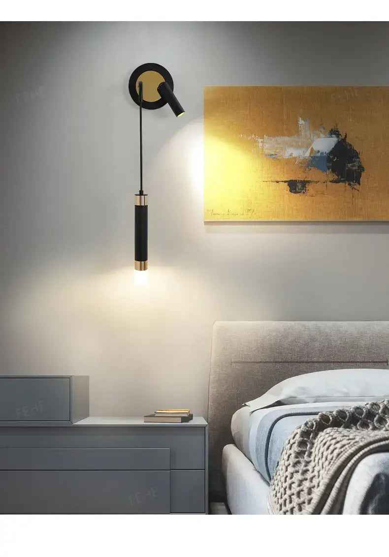 Minimalist creative luxury black and gold modern wall sconce with a cylindrical lampshade designed for luxury bedroom bedside lighting.