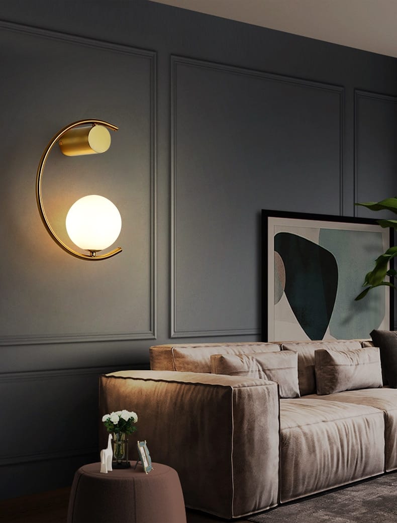 Modern gold luxury creative led bedside wall lamp features a gold-toned crescent-shaped sconce with a frosted glass globe and cylindrical accent for luxury creative led bedroom lighting.