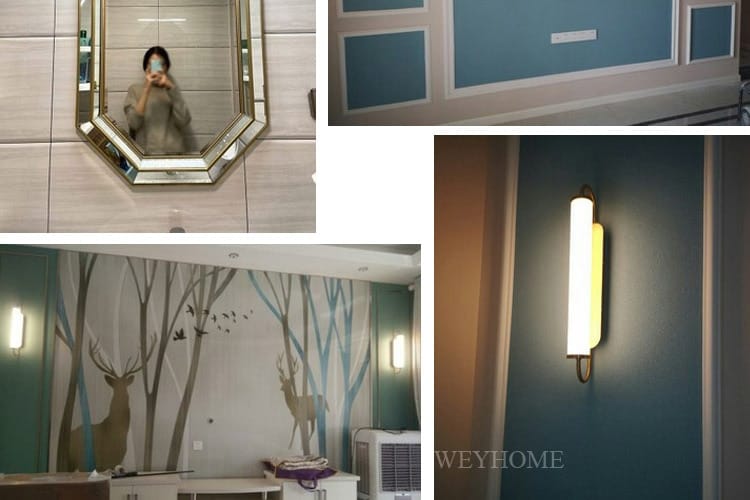 The image shows a modern minimalist gold led wall lamp bedroom cylindrical sconce mounted on blue paneled walls with white molding and an octagonal mirror with a silver frame.