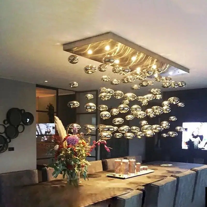 Modern oval bubble ball silver chandelier featuring a metallic rectangular frame with numerous reflective glass orbs suspended below ideal for dining room lighting.