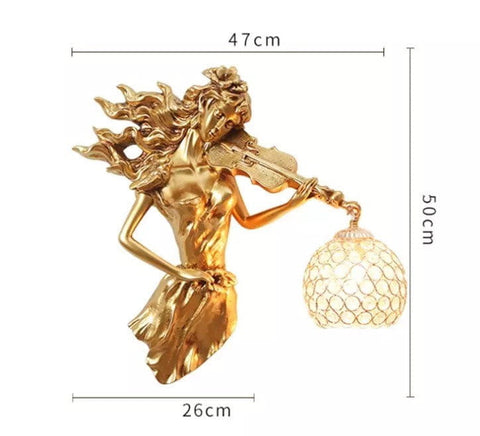 Sculptural gold violinist wall lamp with crystal wall accents featuring a figurine of a woman playing violin with flowing hair holding an ornate lampshade for living room use.