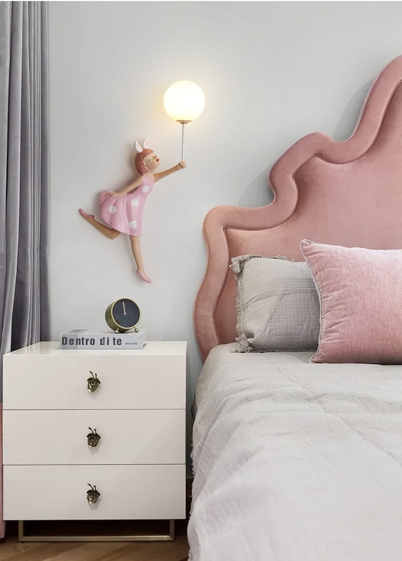 pink velvet headboard with a scalloped cloud-like design complementing a whimsical pink polka dot fairy girl wall lamp for bedroom use
