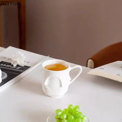 كوب قهوة سيراميكي بتصميم وجه تجريدي من DecorBites™، طاولة طعام، كوب شاي، وعاء عصير