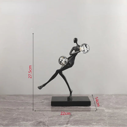 Figura escultórica acrobática de un hombre dorado bailando sobre una bola de cristal DecorBites™ para decoración del hogar