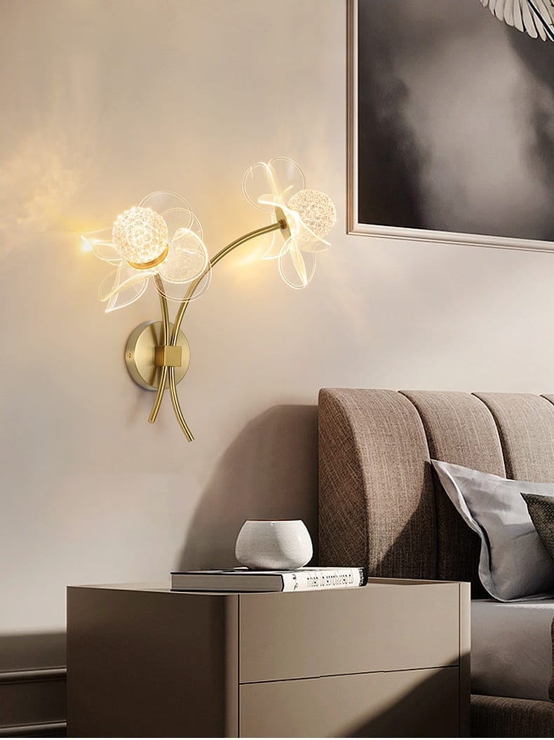 Creative floral decorative gold led wall lamp featuring a gold-toned sconce with two translucent glass flower designs emitting a warm glow for bedroom use.