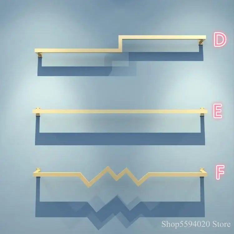 Estante tipo escalera de hierro dorado DecorBites™ para colgar ropa y exhibir prendas con estilo.