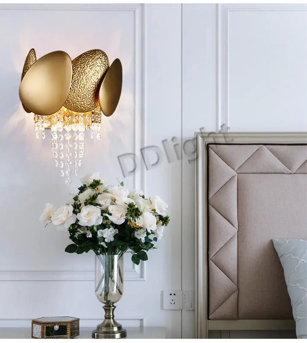 Gold-toned luxury led ceiling chandelier featuring three sculptural textured oval shades with dangling crystal droplets for living room use.
