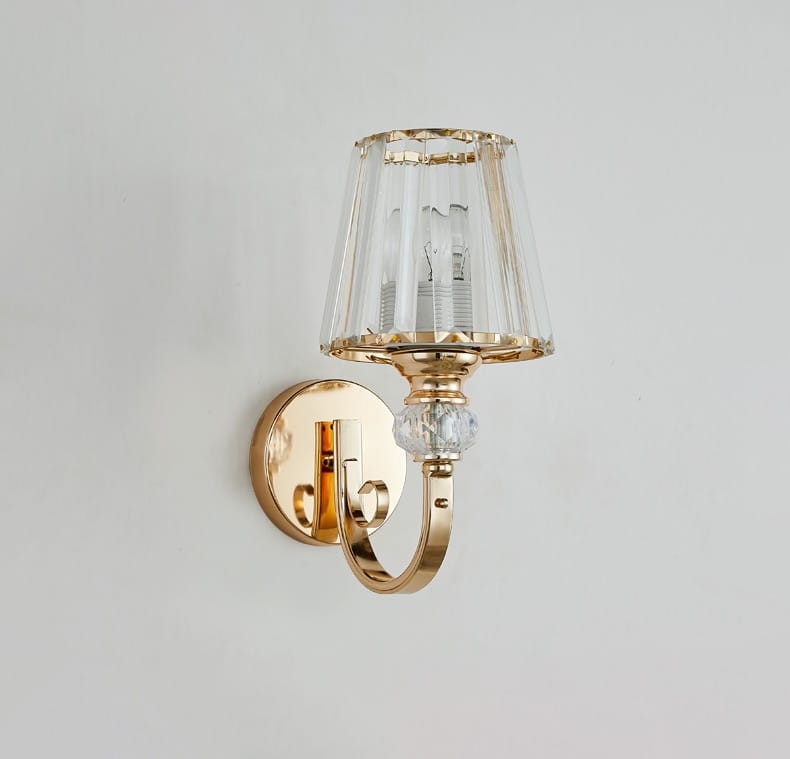 Modern minimalist wall lamp gold finished with a faceted crystal shade and decorative crystal bead for bedroom use.
