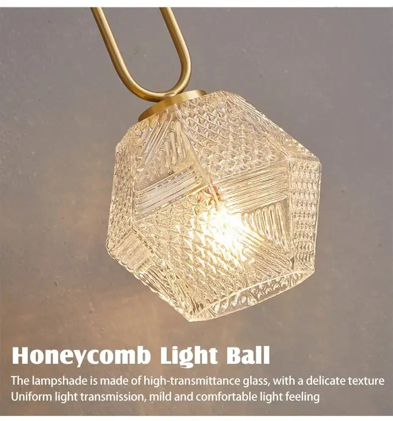 Postmodern luxury led wall lamp featuring a clear faceted honeycomb-shaped crystal glass lampshade with a brass-colored metal fixture for elegant bedroom lighting.