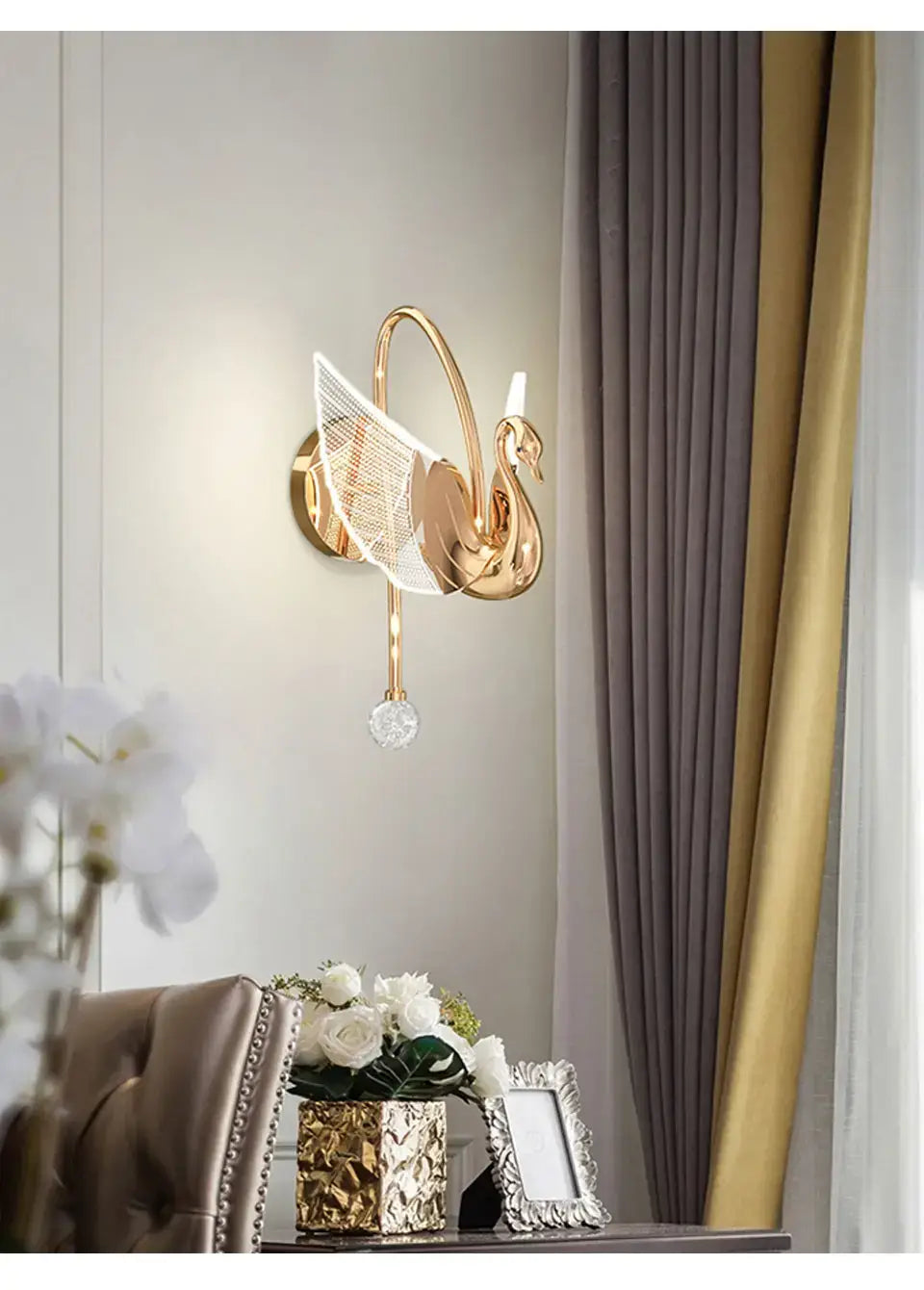 Art deco gold-toned swan wall lamp with translucent wing details and a dangling crystal accent for bedroom bedside wall lighting.