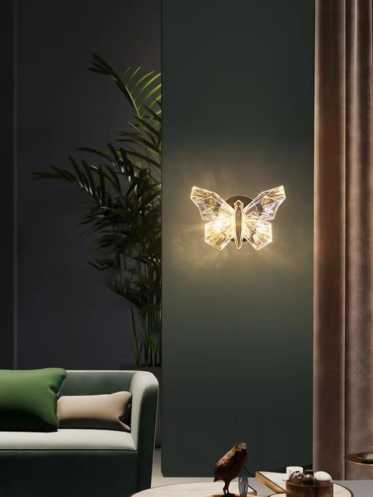 A translucent gold butterfly wall lamp with a geometrically cut design emitting a warm glow, ideal for bedroom lighting.