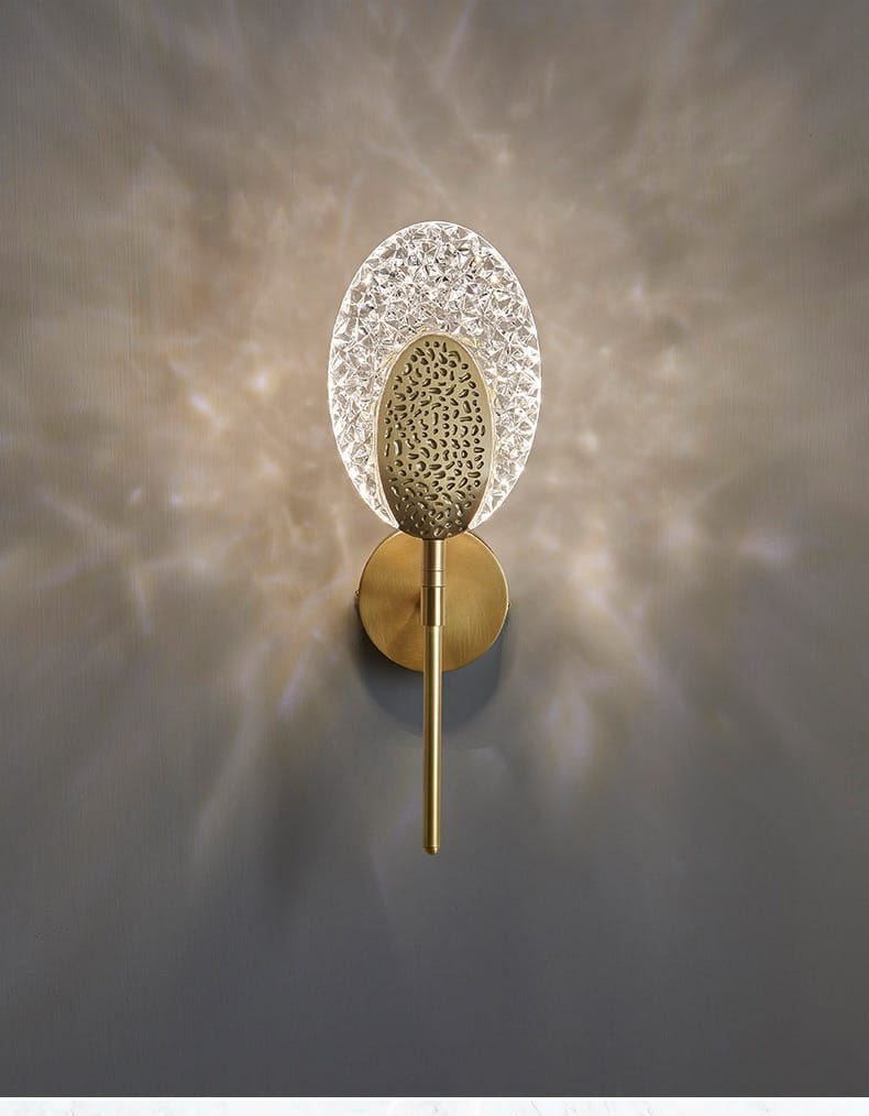gold textured glass led wall lamp featuring a gold-toned wall sconce with a textured oval-shaped crystal diffuser and an intricate patterned metal center for stylish indoor lighting.