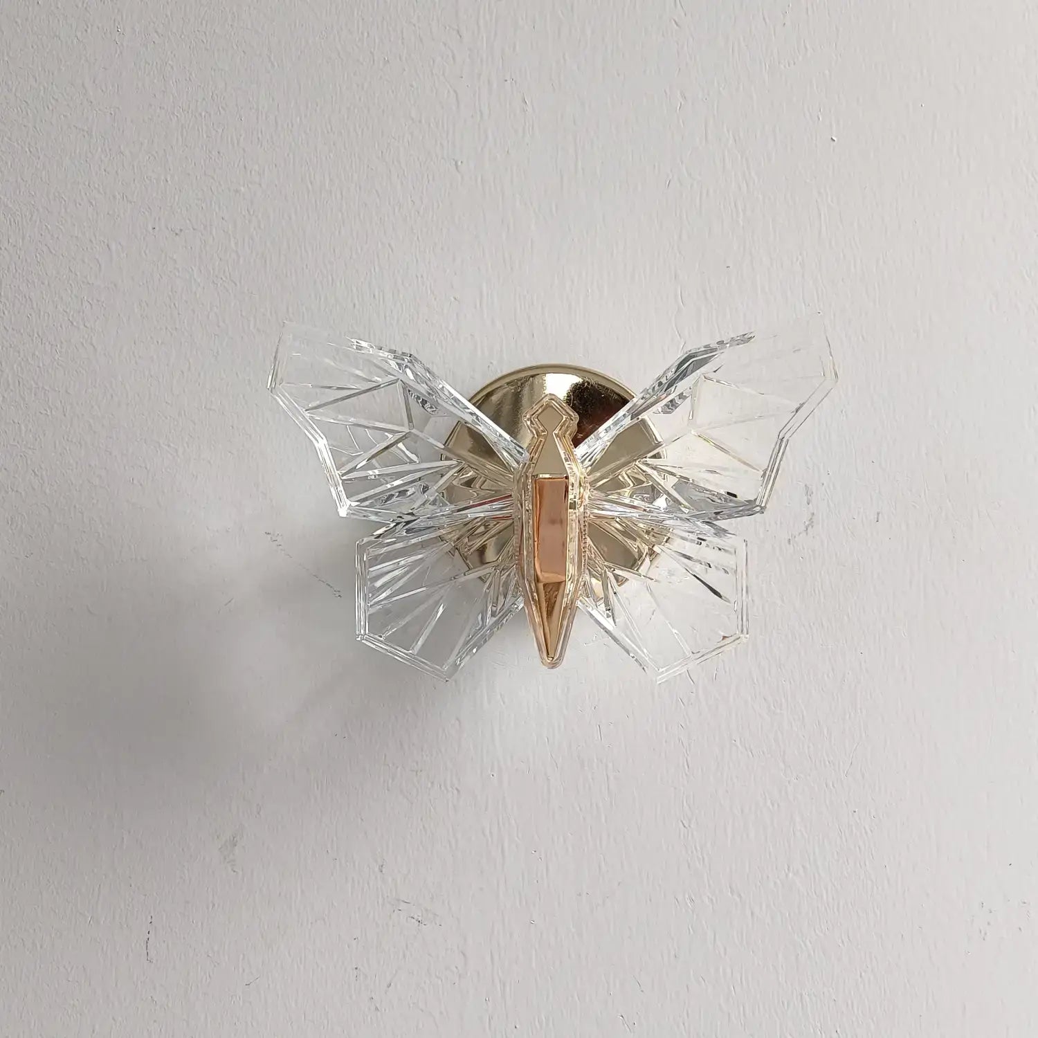 Luxury gold butterfly wall lamp featuring a clear crystal butterfly design with a gold-toned central body for elegant bedroom lighting.