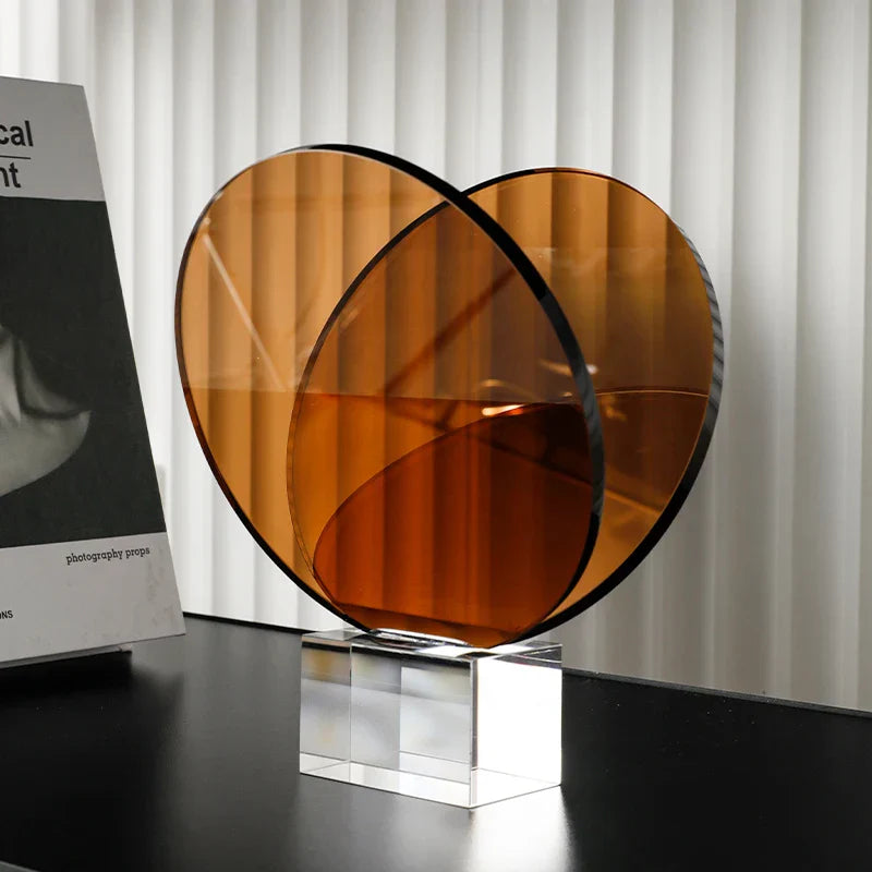 رف كتب ومجلات من ديكوربايتس™ مصنوع من الأكريليك والكريستال، مزين بزخارف هندسية دائرية، وتماثيل صغيرة من العنبر