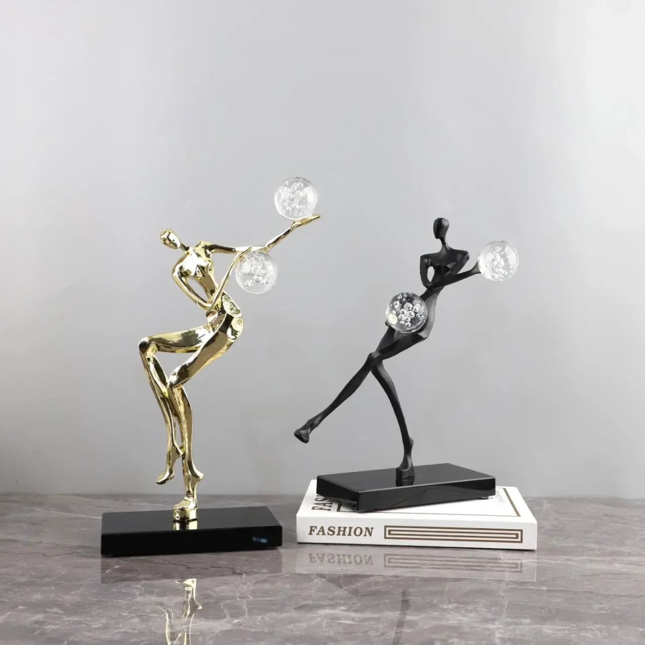 Figura escultórica acrobática de un hombre dorado bailando sobre una bola de cristal DecorBites™ para decoración del hogar