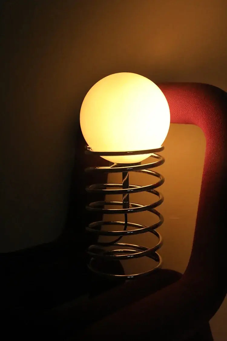 warm glowing white glass bauhaus spring table lamp with chrome spring base for bedroom lighting