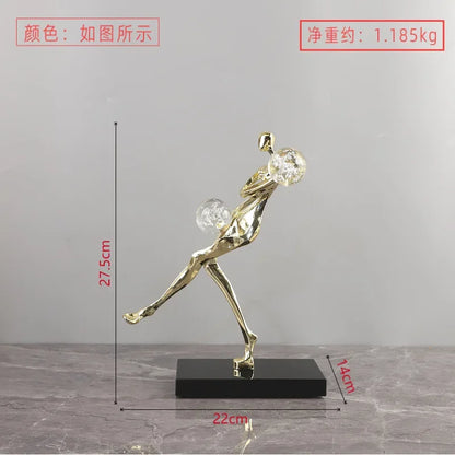 Figura escultórica acrobática de un hombre dorado bailando sobre una bola de cristal DecorBites™ para decoración del hogar
