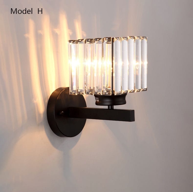 Black metal modern minimalist wall sconce featuring vertical crystal rods designed as a minimalist wall lamp for bedroom use.