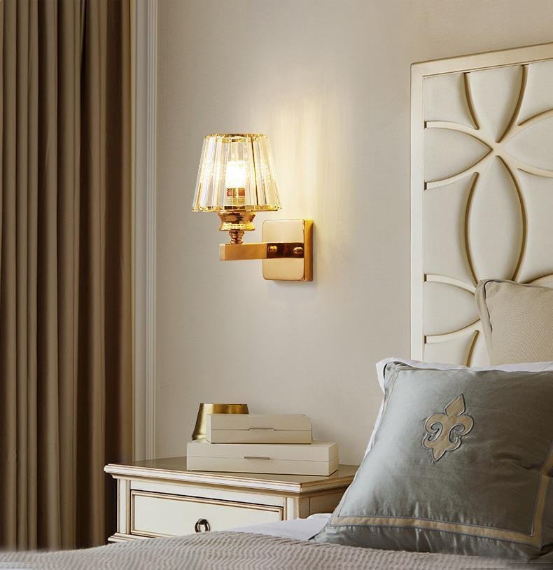Modern minimalist gold wall lamp featuring a gold-toned wall sconce with a faceted crystal shade ideal for bedroom lighting.