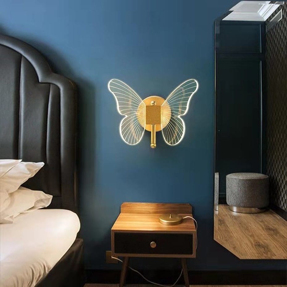 Art deco gold butterfly-shaped wall lamp with illuminated wireframe wings and central circular base for bedroom bedside wall lighting