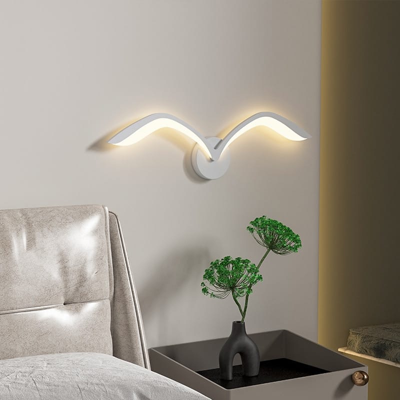 Modern white nordic avian style wall lamp with a sleek curved wing design mounted on a bedroom wall for style indoor use.