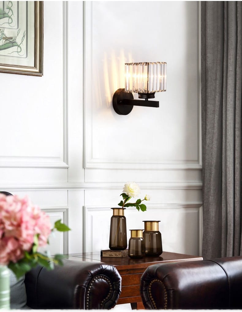 A sleek black modern minimalist wall sconce featuring a faceted crystal shade for bedroom use.