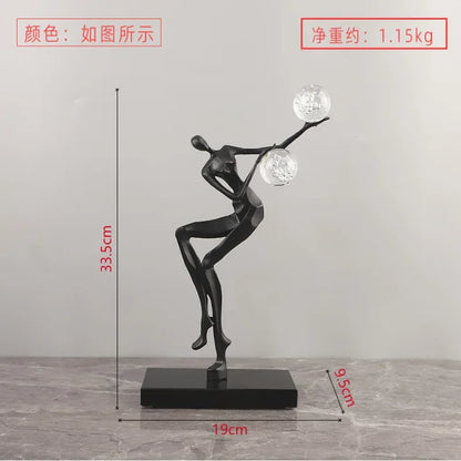 Figura escultórica acrobática de un hombre dorado bailando sobre una bola de cristal DecorBites™ para decoración del hogar