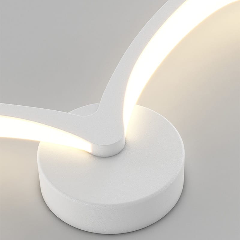 a sleek modern white nordic avian style wall lamp with a curved arm and circular base emitting warm light for style indoor use