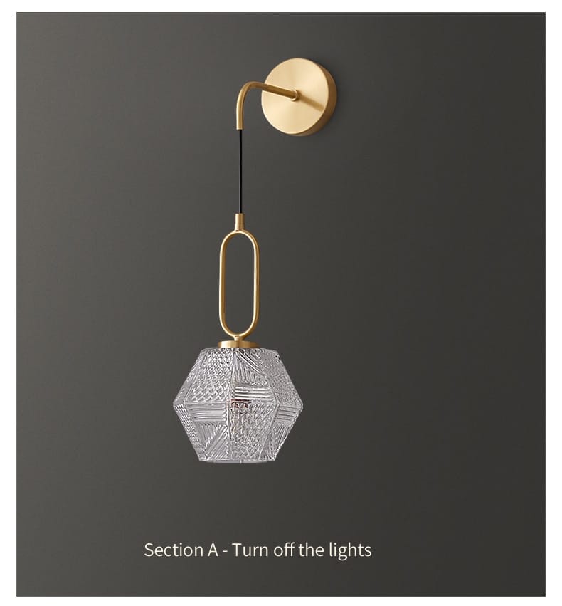 A clear hexagonal glass pendant light with gold-toned metal fixture and chain exemplifying nordic postmodern luxury led design for use as a luxury led wall sconce in bedroom settings.