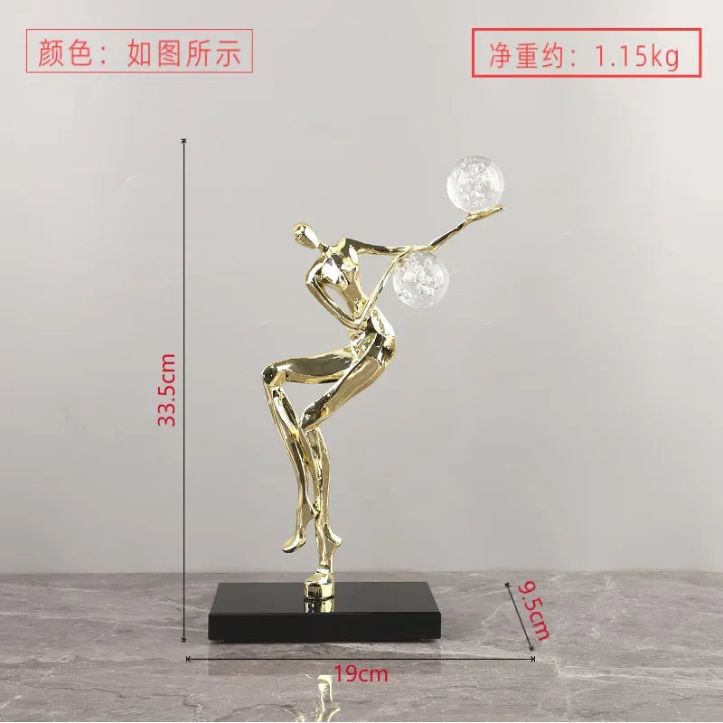 Figura escultórica acrobática de un hombre dorado bailando sobre una bola de cristal DecorBites™ para decoración del hogar