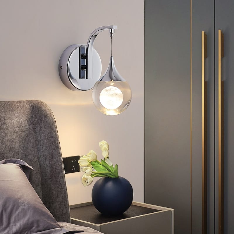 Modern luxurious crystal led wall sconce with chrome finish and teardrop-shaped glass globe for bedroom lighting.